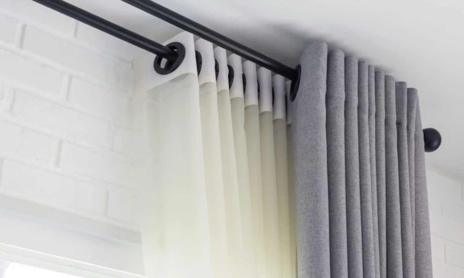 Technician fitting custom eyelet curtains perfectly